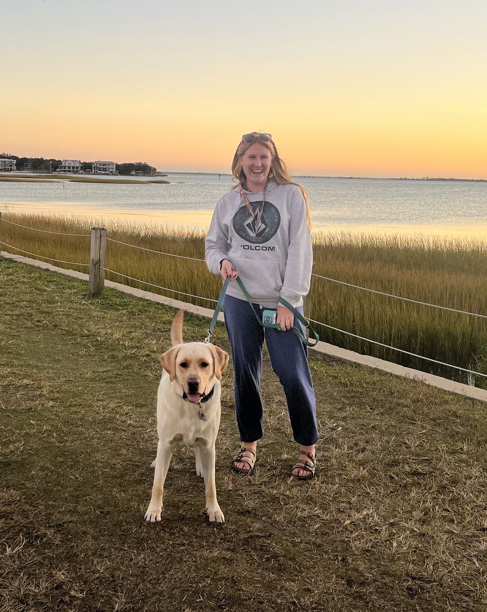 Molly walking Finn along the marsh at sunset in Mount Pleasant